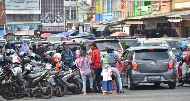 Parkir berlapis di kawasan simpang bata pasar Kota Jambi. Pengunjung pasar membludak, kemacetan tak terhindarkan.