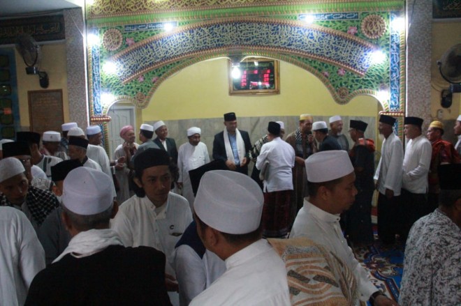 Sy Fasha bersalam-salaman dengan warga usai menunaikan Sholat Ied di Mesjid Magat Sari Pasar Jambi (15/06)