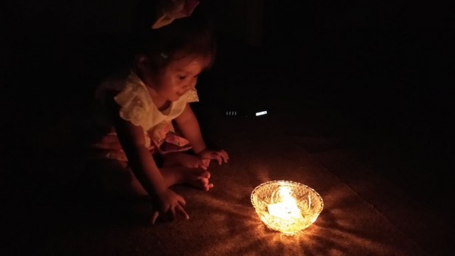 Seoarang anak di Kerinci bermain dengan hanya menggunakan penerangan lilin 