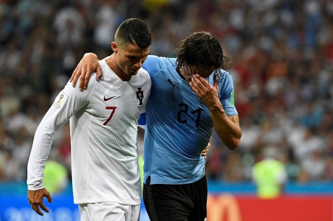 Edinson Cavani saat dipapah Cristiano Ronaldo untuk mendapat perawatan. (AFP)