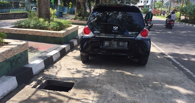 Lobang besar di badan jalan membahayakan pengendara. Manhole hilang dicuri. 