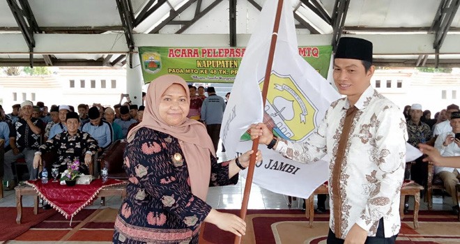 Bupati Masnah menyerahkan Pataka Kontingen MTQ Muarojambi kmpuk pada Ketua Kontingen MTQ Sekda Muarojambi Fadhil Arif.