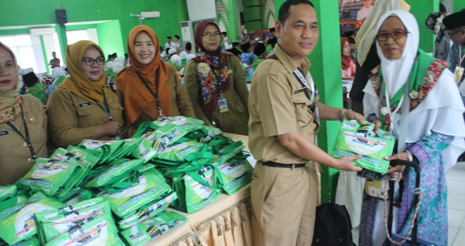 Ketua DWP DKP Provinsi Jambi Aspita Temawisman SE saat menyerahkan sambal lingkung kepada salah satu JCH.