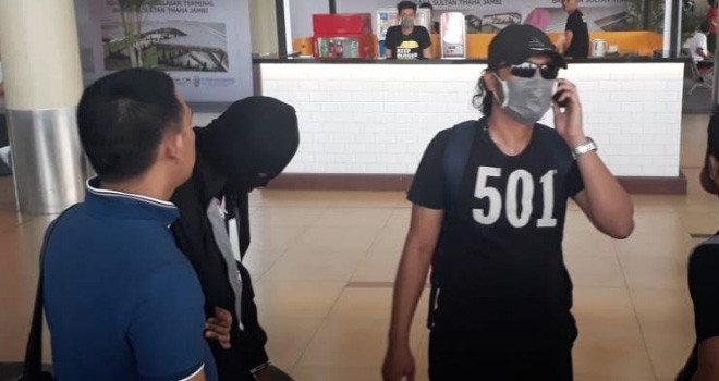 Petugas saat menggiring dua pengedar narkoba melalui Bandara Sultan Taha Jambi, Minggu (19/8).      