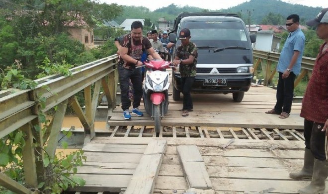 Masyarakat Desa Muara Mensao melakukan gotong royong perbaikan jembatan, yang merupakan akses utama masyarakat setempat.   