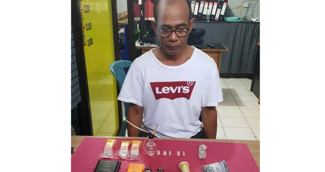 Tersangka Marihot Panggabean saat diamankan bersama dengan barang bukti di Mapolres Kerinci, Kamis (30/8).