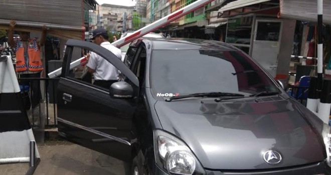 Salah satu mobil pengunjung pasar Kota Jambi rusak ditimpa pelang parkir kawasan simpang bata, kemarin (4/9).