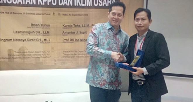 Ihsan Yunus (kiri) menerima plakat usai menjadi pembicara pada seminar terkait persaingan usaha.