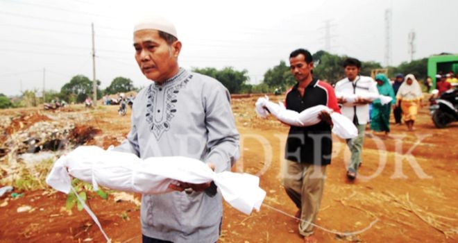 sejumlah orang memindahkan jenazah anggota keluarganya, ke tempat pemakaman yang baru. (AHMAD FACHRY/RADAR DEPOK/ JAWA POS GROUP)