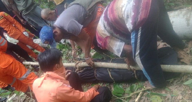 Pihak kepolisian, Basarnas dan warga saat mengevakuasi korban Taufik di sebuah kebun di Desa Rantau Langkap, Jumat (28/9).