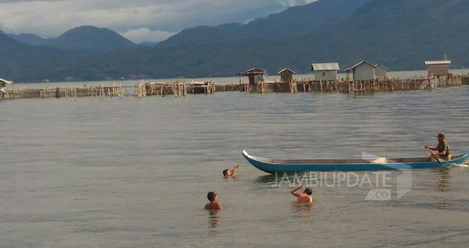 Anak-anak bermain sambil membantu nelayan mencari ikan di Danau Kerinci. 