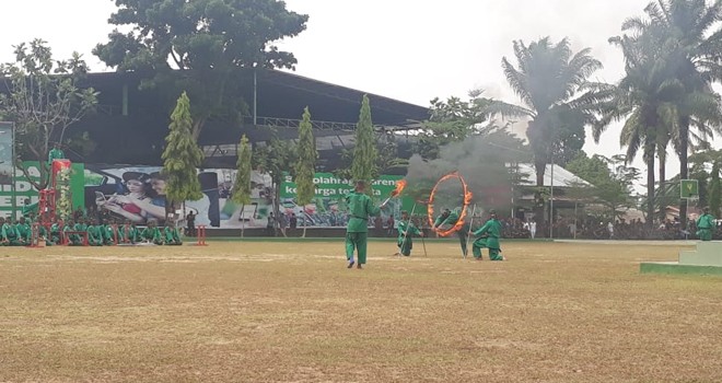 Sejumlah anggota TNI menunjukkan kemampuannya melewati rintangan api yang dibuat berbentuk gelang.