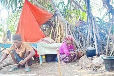 TRAUMA: Suami-istri Saad dan Sasrani beraktivitas di halaman samping rumahnya di Dusun Jam Busok, Desa Prambanan, Kecamatan Gayam, Sumenep. (MUSTAJI/Radarmadura.id)