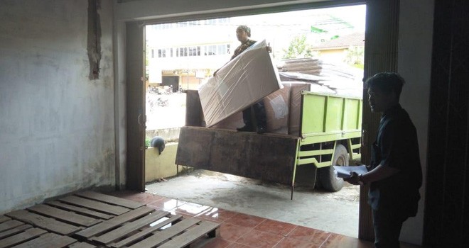 Petugas ekspedisi menurunkan logistik berupa bilik suara untuk disimpan di gudang jelang pemngutan suara Pemilu.