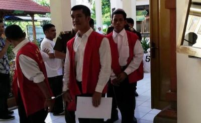 KECANDUAN GAME: Terdakwa Yosia (pegang kertas) usai menjalani sidang tuntutan di PN Denpasar, Jumat lalu. (Istimewa)