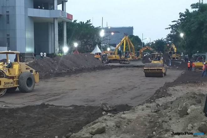 Proses perbaikan Jalan Raya Gubeng, Senin petang (24/12). (Aryo Mahendro/ JawaPos.com)