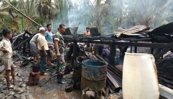 Anggota Danramil Tungkal Ilir saat membantu membersihkan puing-puing sisa kebakaran rumah Zulkifli yang berada di Parit 4 Darat, Manunggal 2, Kelurahan Tungkal II, Kecamatan Tungkal Ilir, Kabupaten Tanjab Barat, Sabtu (29/12) siang. Foto : Gatot / Jambiupdate