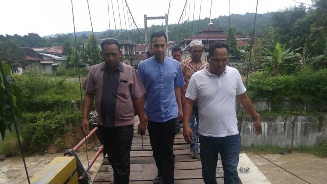 FOTO : IST/JE BLUSUKAN : Calon anggota DPR RI Dipo Nurhadi Ilham harus melewati jembatan untuk mengunjungi, berdialog serta menyerap aspirasi masyarakat. 