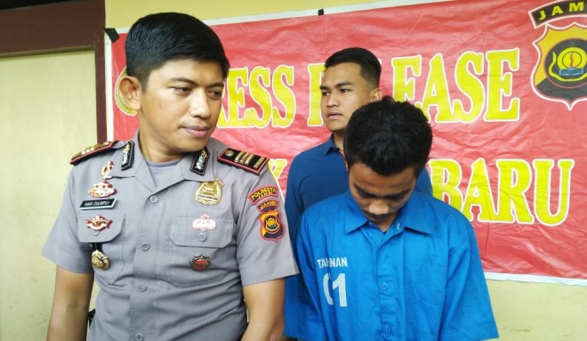 Remaja yang membakar rumah orang tua nya saat di amankan Polisi. Foto : Ist