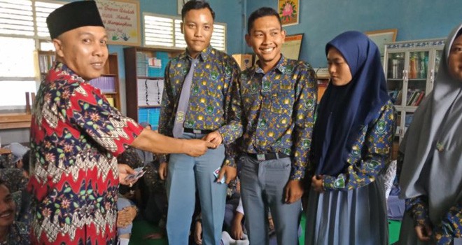 Helmi, Kadis Dukcapil menyerahkan E-KTP kepada siswa beberapa waktu lalu. Foto : Hadinata