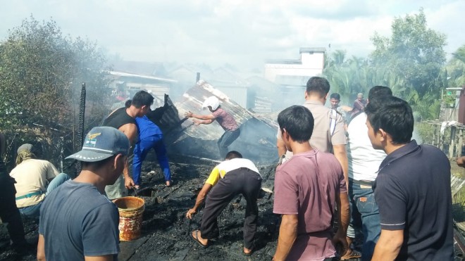 Warga bersama dengan petugas saat membantu membersihkan puing-puing bangunan rumah milik Kasmat di RT 12 RW 03, Kelurahan Kampung Laut, Kecamatan Kuala Jambi, Kabupaten Tanjab Timur, yang ludes dilalap si jago merah, Jumat (8/2). Foto : Ist For Jambiupdate