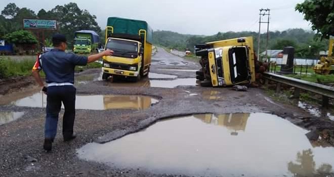 Kondisi Jalan Lintas Sumatra Bungo â€“ Dharmasraya, saat ini kondisinya rusak berat. Terlihat Petugas Dishub Bungo saat mengatur lalu, ketika ada kendaraan truk terbalik di jalan yang rusak berat ini. Foto : Ferdian / Jambiupdate