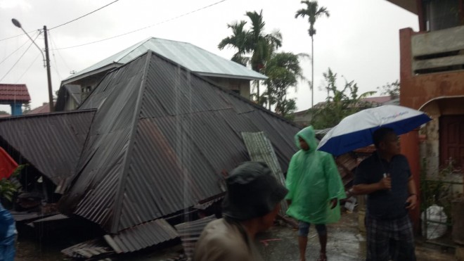 Dihantam angin puting beliung, atap rumah warga terbang hingga menutupi jalan, Jumat (22/02). 