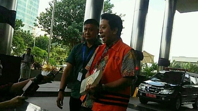 Rommy hendak masuk gedung KPK dengan tangan diborgol sambil memegang buku, Jumat (21/3). (Intan Piliang/JawaPos.com)