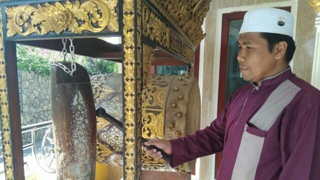 Ibrahim tengah memukul bedug tanda memasuki waktu salat. (Alwi Alim/ JawaPos.com)