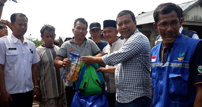 Bupati Tanjabtim, Romi ketika menyerahkan bantuan untuk korban kebakaran di Desa Lambur Luar.