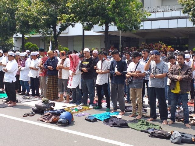 Massa menggelar salat dzuhur di Jalan MH Thamrin, Jakarta Pusat. (Sabik Aji Taufan/ JawaPos.com)
