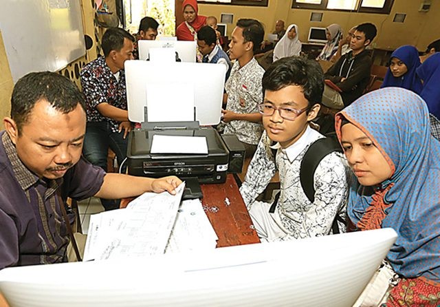 Panitia penerimaan peserta didik baru SMAN 14 melayani sejumlah orang tua dan calon siswa yang mengambil PIN kemarin. (Robertus Risky/Jawa Pos)