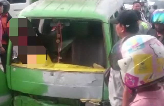 Angkot yang berwarna hijau ringsek bagian depannya karena menabrak tiang listrik di kawasan Jelutung. Foto : Ist