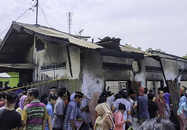 Warga melihat kondisi rumah yang ludes terbakar. Rumah itu digunakan sebagai pabrik korek api Macis. (Teddy Akbari/Sumut Pos)