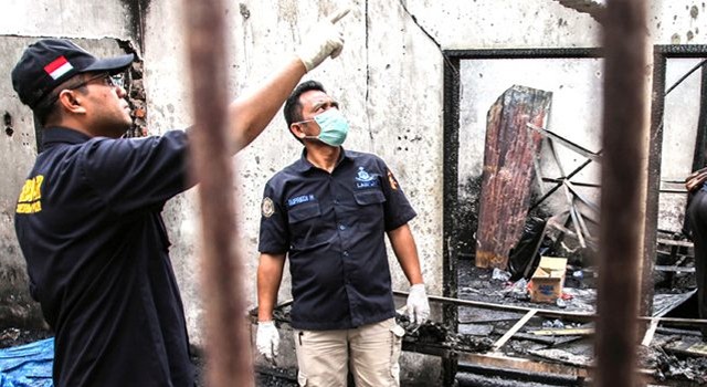 AMATI PUING: Petugas mencari bukti baru di pabrik macis di Binjai yang terbakar Jumat lalu (21/6). (Ivan Damanik/AFP)