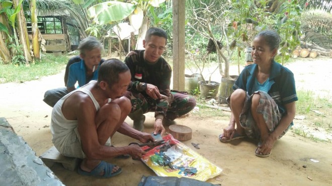 Kebersamaan Babinsa Koramil 415-04/Mb, Serda Sahardi bersama warga Desa Ladang Peris. 