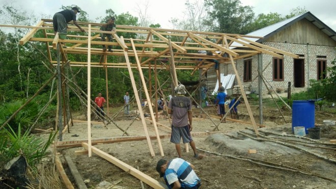 Sersan Dua (Serda) Alfian membantu warga RT 08 Desa Ladang Peris. 