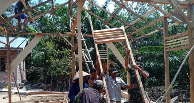 Babinsa Serda Tri Purwanto saat Gotong Royong Bersama Warga Bangun Rumah Supar.