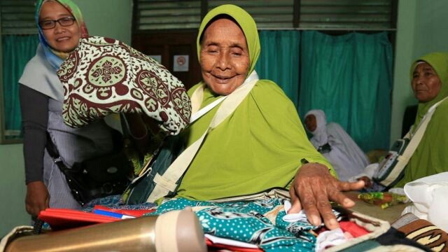 Tiwa binti Sajirun sedang menata barang-barang di tas tentengnya. Dia merupakan jamaah tertua dengan usia 103 tahun. (Robertus Risky/Jawa Pos)