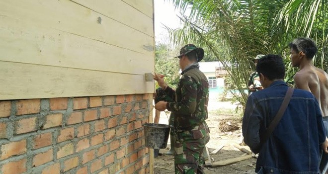 Babinsa Serda Alfian Bantu Warga Bangun Rumah Mamat.