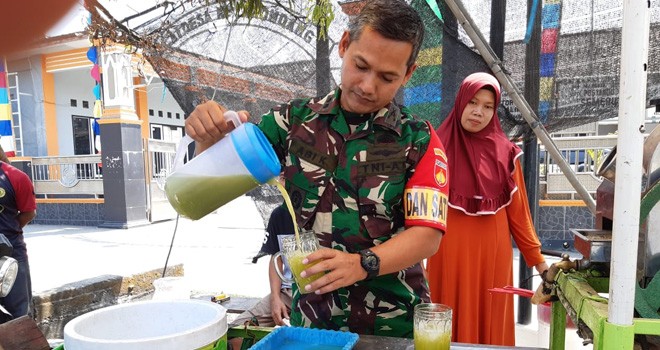 Dansatgas TMMD Kodim Demak bikin ramuan Es Tebu Tarik.
