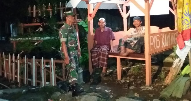 Satgas TMMD Dan Warga jaga di Poskamling.