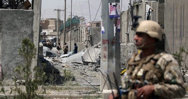 Seorang tentara Afghanistan menjaga lokasi ledakan bom di depan kantor polisi Kabul, Rabu (7/8) (STR / AFP)