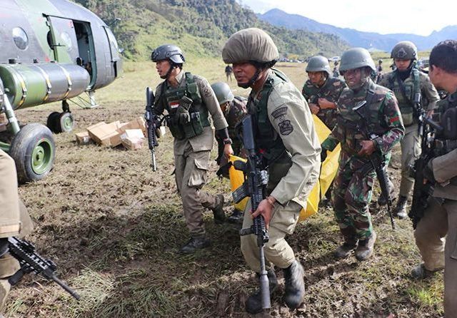 ILUSTRASI: Pasukan TNI dan Polri mengevakuasi jenazah korban kebiadaban dari Kelompok Kriminal Separatis Bersenjata (KKSB) Papua. (Cenderawasih Pos/Jawa Pos Group)