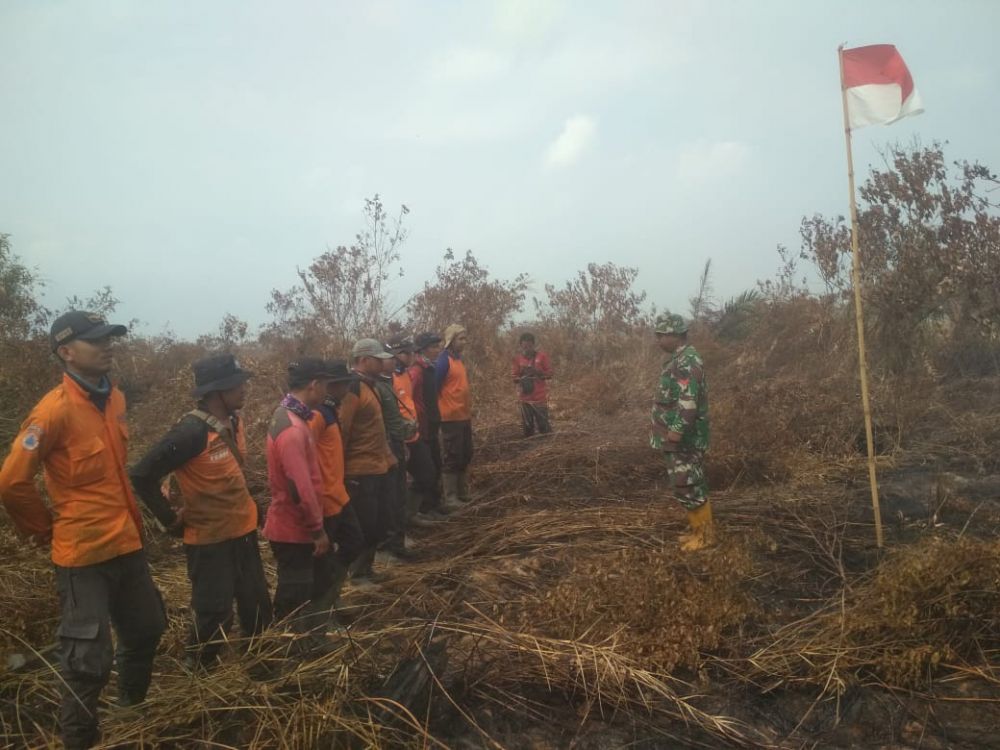 Peringatan HUT RI yang digelar Satgas Karhutla di tengah sisa-sisa kebakaran lahan di Desa Sungai Sayang, Kecamatn Sadu, Tanjab Timur.