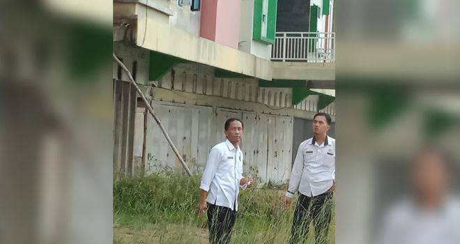 Kabid Kawasan Permukiman,Dinas Perkim, Heri Antoni, saat melakukan penggecekan bangunan.

 
