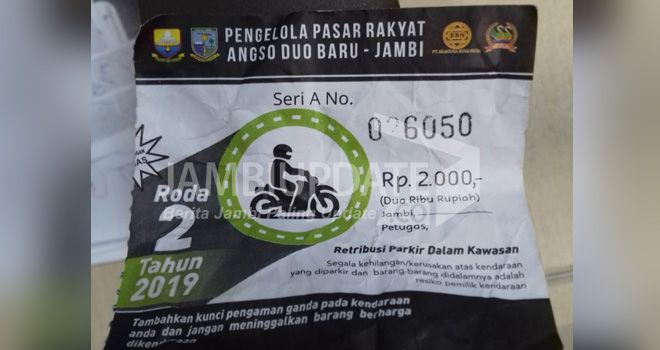 Spanduk pemberitahuan pungutan parkir bagi pengunjung Pasar Angso Duo. Di karcis tertulis logo Pemprov Jambi. Pemprov keberatan karena tidak kordinasi.


