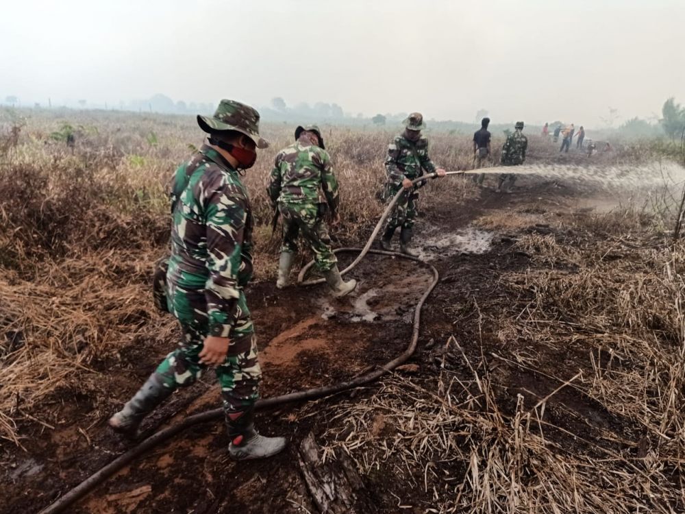 Terlihat petugas tengah memadamkan api.