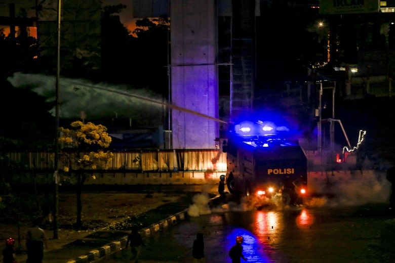 Water canon dan tembakan tear gas memukul mundur pengunjuk rasa saat bentrok di Fly over, Jumat, 27 September. 