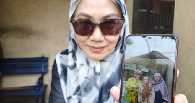 Tetangga Almarhumah Atikah Baswedan, Dian Niode memperlihatkan foto almarhumah (tengah). 